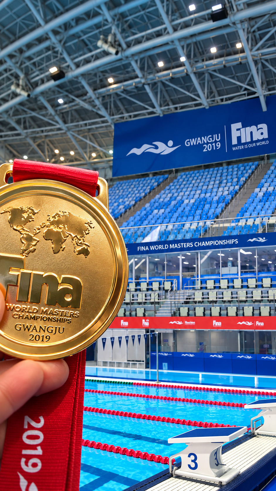 Medalla de oro del Campeonato Mundial de Natación Master FINA Gwangju 2019 frente a la pileta de competencia